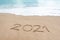 Hello 2021 sign on the sandy beach with soft wave of white foam. Welcoming 2021 with new resolutions, dreams concept