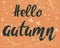 Hello autumn, banner. Vector calligraphic postcard. Hand lettering with falling leaves. Orange seasonal fall background.