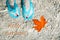 Hello, autumn card. Turquoise flip flops underwater and orange torn maple leaf. Clear water. Autumn at sea, Croatia