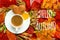 HELLO Autumn, fall leaves, hot steaming cup of coffee and a warm on table background. Seasonal, morning coffee, Sunday relaxing