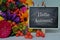 Hello Autumn text on mini chalkboard and colorful flowers on the table