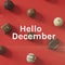 Hello december text over christmas chocolates on red background