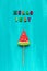 Hello July text from colorful letters and watermelon lollipop on stick on wooden blue background. Concept Creative Top