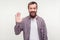 Hello! Portrait of good-natured positive bearded man waving hand and friendly smiling at camera. white background