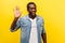 Hello! Portrait of positive handsome man smiling friendly and waving hand saying hi. indoor studio shot isolated on yellow