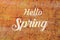 Hello Spring lettering over osb material background. Calligraphy text on wooden texture.