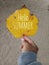 Hello summer text on an autumn leaf in yellow color. A young woman hand holds the leaf with white sands background. Human body