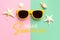 Hello Summer. Top view of yellow sunglasses, starfish, seashells and the text Hello Summer. Summer vacation concept