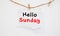 Hello Sunday Card with Blooming flower on wooden background