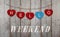 Hello weekend written on hanging red and blue wooden hearts