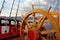 Helm wheel of an old wooden sailboat. Details of the deck of the ship