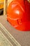 Helmet builder worker head protection provides health, bright noticeable orange plastic lies on the building material