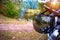 A helmet hanging on the helm of a motorcycle against a picnic in the forest