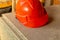 Helmet made of bright orange plastic, lightweight reliable protection of the head of the worker