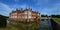 Helminngham Hall with moat bridge and reflections.