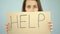 Help message on poster in unhappy woman hands, victim of crime begging support