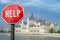 Help stop sign with view of parliament in Budapest, Hungary