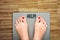 Help to lose kilograms with woman feet stepping on a weight scale