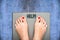 Help to lose kilograms with woman feet stepping on a weight scale