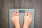 Help to lose kilograms with woman feet stepping on a weight scale