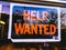 Help Wanted Sign Hanging On Business Window