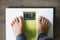 Help your child to have a healthy diet and lifestyle, with obese kid feet on weight scale, under the supervision of the mother