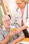 Helpful Doctor or Nurse Explaining Prescription Medicine to Attentive Senior Man
