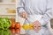 Helpful man preparing salad in kitchen