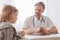 Helpful pediatrician and sick blond boy in a doctor`s office