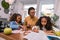 Helpful smart nursery teacher wearing glasses teaching two girls letters