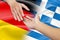 Helping hands with german and greece flags