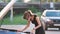 Helpless woman standing near her car with open bonnet inspecting broken motor. Young female driver having trouble with