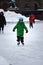 Helsinki, Finland - January 15th 2018: A cute young boy with a green coat skating in Helsinki, Finland