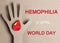 Hemophilia World Day background. Silhouette of a hand with a drop of blood on a cardboard background