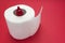 Hemorrhoid, treatment health problems. Toilet paper and crochet blood drop on the red background.