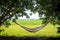 Hemp hammock hanging between the trees with grass field, rice padding background. slow life in the countryside.