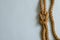 Hemp rope with a nautical knot on a light blue background