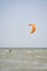 Henichesk, Ukraine - July 12, 2021: Kitesurfing. Practicing kitesurfing at summer beach. Kitesurfer doing tricks. People enjoy