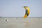 Henichesk, Ukraine - July 12, 2021: Surfer in wetsuit do trick. Kitesurfing athlete on kite board. Foiling kiteboarding