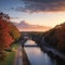 the Henley Street Bridge over the Tennessee River surrounded by autumn colored trees, lush green trees and office