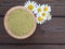 Henna powder in the coconut bowl and chamomile flowers