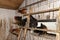 Hens standing on a wooden ladder in a chicken coop with dirty walls.