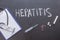 Hepatitis, a concept on a chalkboard. Stethoscope, pills, syringe and a piece of pape