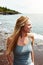 She is in her element. a cheerful young woman standing on a beach while looking out at the ocean outside during the day.