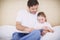 Her favourite picture book. A devoted father reading his young daughter a bedtime story.