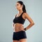 Her focus is unmatched. Studio shot of an athletic young woman posing with her hands on her hips against a grey