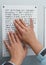 Her hands reading Braille table