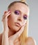 Her makeup is striking. Closeup portrait of a pretty young woman wearing brightly colored makeup.