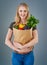 Her mom taught her to eat her veggies. Cropped studio shot of a young woman holding a paper bag full of vegetables.