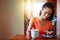 Her morning begins with coffee and an internet catchup. a smiling young woman sitting at her dining table at home